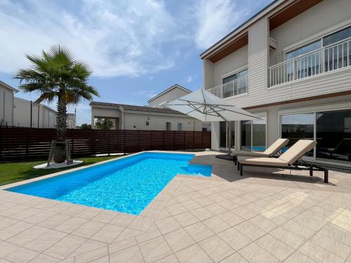 a swimming pool in front of a house at Dog Resort D&K-ドッグリゾートD&K- in Futtsu