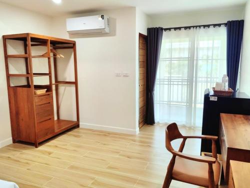 a room with a table and a chair and a book shelf at Bewarm บีวอร์ม เชียงราย in Ban San Ton Ko (1)
