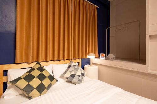 a bedroom with a bed with two pillows and a window at Siam Twin Charoenkrung in Bangkok