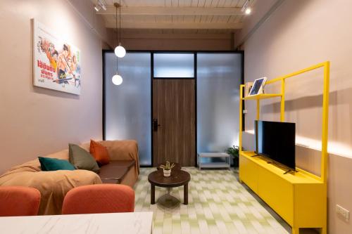 a living room with a couch and a tv at Siam Twin Charoenkrung in Bangkok