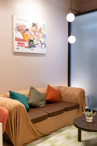 a living room with a couch and a movie poster at Siam Twin Charoenkrung in Bangkok