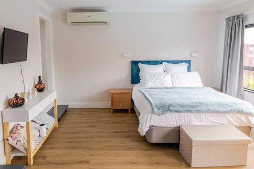 a bedroom with a large bed with a blue headboard at On The Beach in Napier