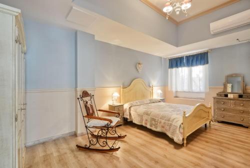 1 dormitorio con cama, silla y vestidor en La Bouganville Holiday House, en Agropoli