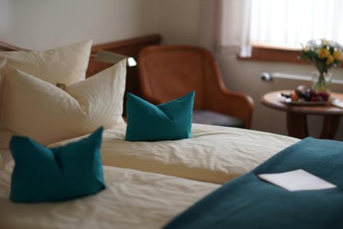 a bedroom with a bed with blue pillows at Landhaus Wacker in Wenden