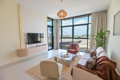 a living room with a couch and a large window at Rooftop Pool - Designer's Choice - Full Canal View in Abu Dhabi