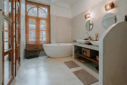 a bathroom with a large tub and two sinks at The Oasis Villa in Ahangama