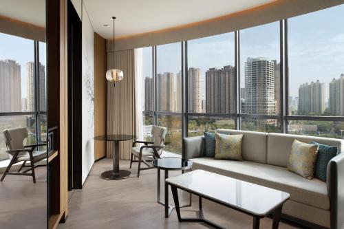 a living room with a couch and tables and windows at Fairfield by Marriott Xi'an Chanba in Xi'an