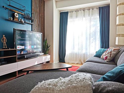 a living room with a couch and a flat screen tv at LakePark Artsy 3 bedroom Townhouse 1 Parking in Toronto