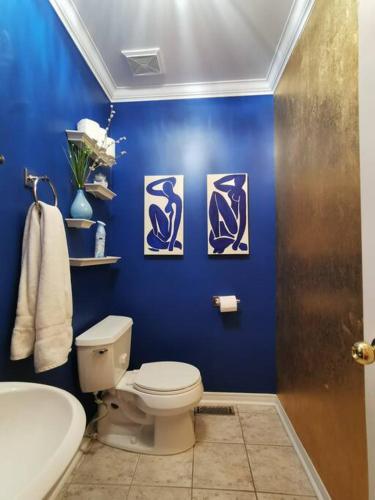 a bathroom with a toilet and a blue wall at LakePark Artsy 3 bedroom Townhouse 1 Parking in Toronto