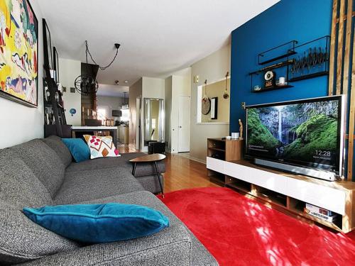 a living room with a couch and a large television at LakePark Artsy 3 bedroom Townhouse 1 Parking in Toronto