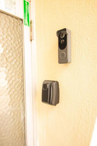 a door with a security camera attached to it at BRUCE GUESTHOUSE KIX in Izumi-Sano