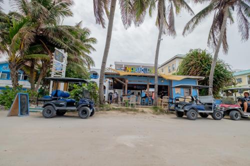 dos carros de golf estacionados frente a un edificio en Seven Seas Resort Adults Only, en San Pedro