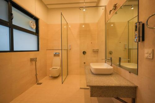 a bathroom with a toilet and a sink and a shower at UNA Services - Margalla Retreat in Islamabad