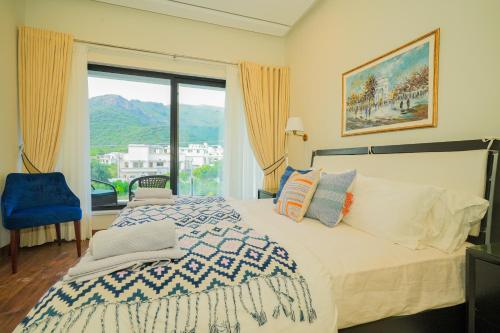 a bedroom with a bed and a large window at UNA Services - Margalla Retreat in Islamabad