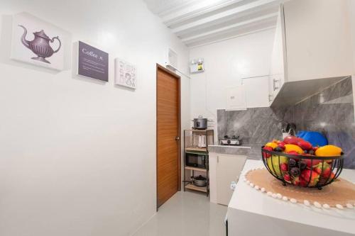 a kitchen with a bowl of fruit on a table at Unit 101 - Your Cozy Batangas Retreat in Batangas City