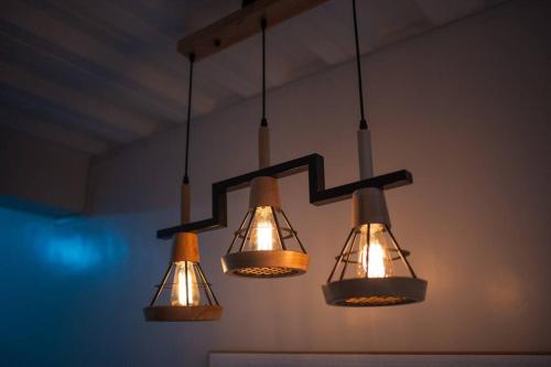 a group of three lights hanging from a ceiling at Unit 101 - Your Cozy Batangas Retreat in Batangas City