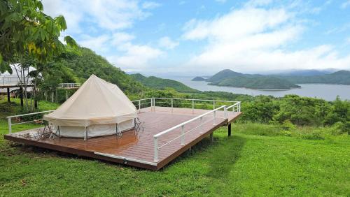 a tent on a wooden deck with a view of a lake at The Hilltop Erawan in Si Sawat