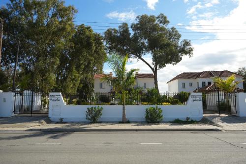 a white fence in front of a house at Meneou Houses by the Sea in Larnaka