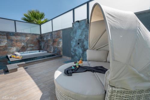 a living room with a chair and a tub at Naomi Boutique Suites in Netu'a