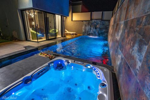 a swimming pool with a hot tub in a house at Naomi Boutique Suites in Netu'a