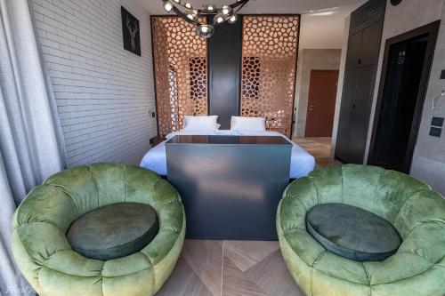 two green ottoman chairs in a hotel room at Naomi Boutique Suites in Netu'a