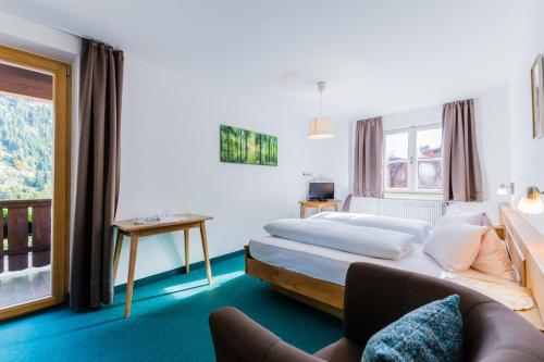 a hotel room with a bed and a couch at Gasthof Platterwirt in Moso