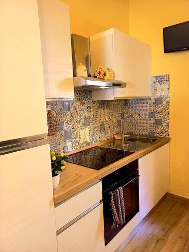 a kitchen with white cabinets and a sink at Villino I Girasoli in Chianni