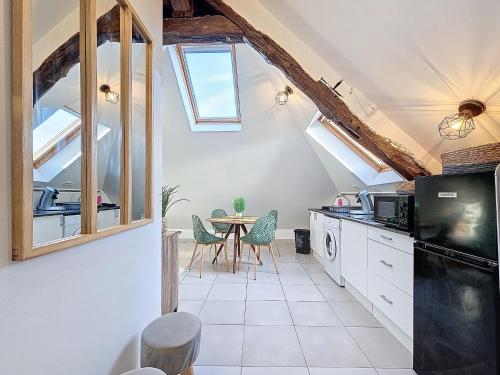 une cuisine avec des lucarnes et une table avec des chaises dans l'établissement Proche Disney 15 minutes et Paris-Bercy en 25 minutes, à Annet-sur-Marne