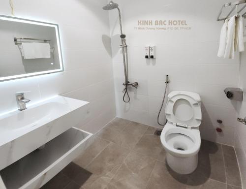 a white bathroom with a toilet and a sink at Khách sạn Kinh bắc in Ho Chi Minh City
