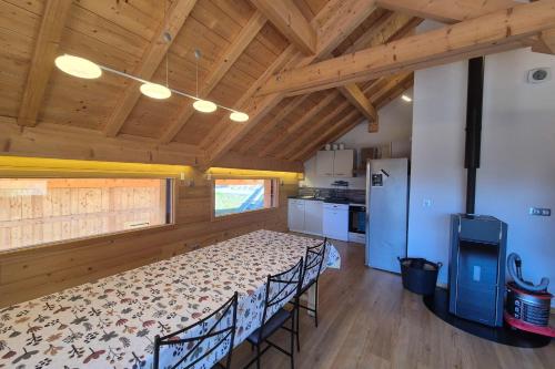 une pièce avec une table et des chaises dans une cuisine dans l'établissement Chalet Cozy au Cœur de La Féclaz Séjour Authentique et Proche des Pistes, à La Féclaz