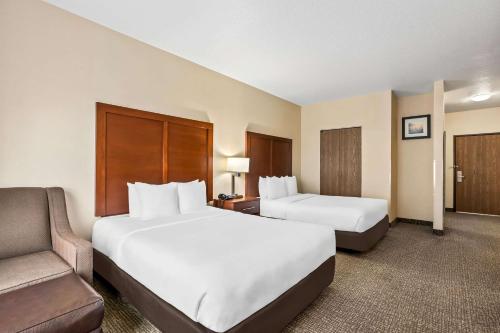 a hotel room with two beds and a couch at Comfort Inn & Suites Hermiston South in Hermiston