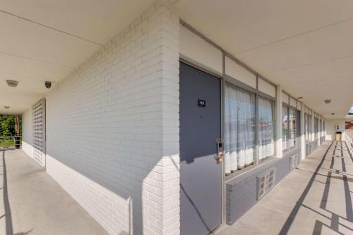 a white brick building with a blue door at Econo Lodge Fort Knox in Radcliff