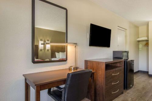 a desk with a chair and a mirror in a room at Econo Lodge Fort Knox in Radcliff
