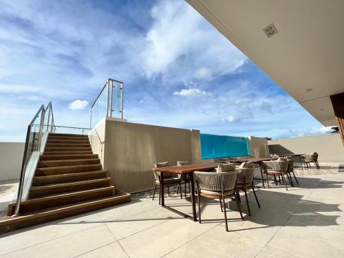 a patio with a table and chairs and stairs at Uma Hotel and Residences in Naga