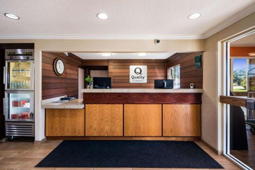 a bar in a restaurant with a clock on the wall at Quality Inn & Suites Bozeman in Bozeman