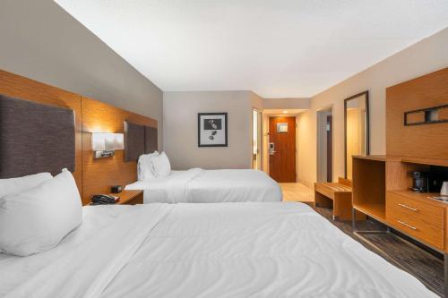 a hotel room with two beds and a television at MainStay Suites Springfield IL in Springfield