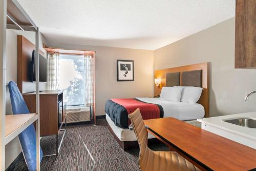 a hotel room with a bed and a sink at MainStay Suites Springfield IL in Springfield