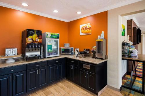 a kitchen with orange walls and a counter with a refrigerator at Quality Inn & Suites Bozeman in Bozeman
