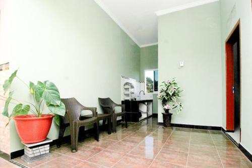 a waiting room with chairs and a potted plant at Urbanview Griya Lota Guest House Banyuwangi in Ketapang