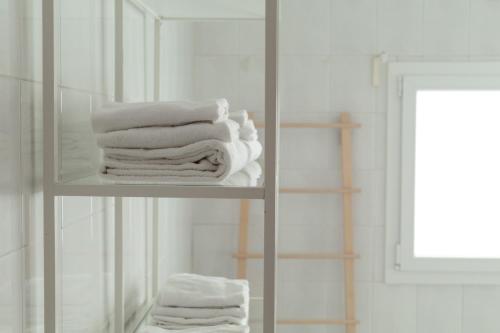 a stack of towels on a shelf in a bathroom at Spacebility Airport - self check-in in Cagliari