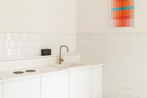 a kitchen with white cabinets and a sink at Spacebility Airport - self check-in in Cagliari