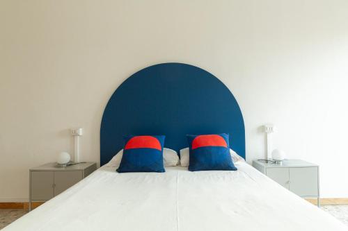 a bed with two red and blue pillows on it at Spacebility Airport - self check-in in Cagliari