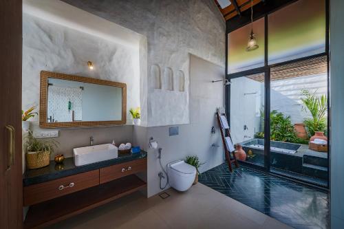 ein Badezimmer mit Waschbecken, Badewanne und Toilette in der Unterkunft SaffronStays Ikigai in Wādhiware