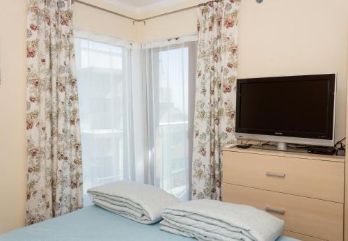 a bedroom with a flat screen tv and a window at Balchik Sea View Escape 5BR Luxury with Hot Tub & Free Parking in Balchik