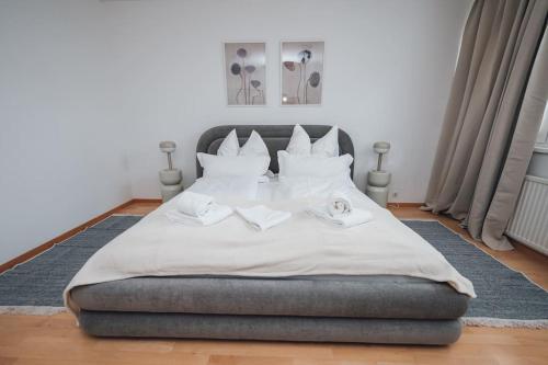 a bedroom with a large bed with white sheets at Designer-Apartment zum Wohlfühlen in Vienna