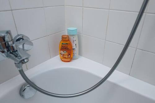 a bottle of orange cleaner sitting on a bathroom sink at Designer-Apartment zum Wohlfühlen in Vienna