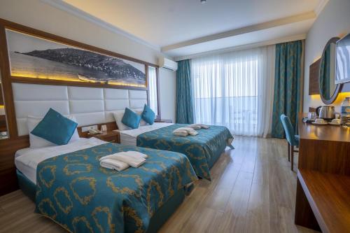 a hotel room with two beds and a window at Sun Star Resort Hotel in Alanya