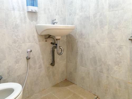 a bathroom with a sink and a toilet at Urbanview Griya Lota Guest House Banyuwangi in Ketapang