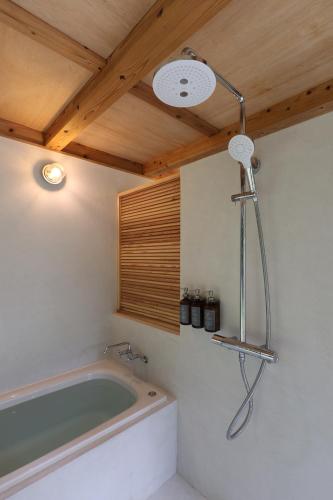 a bath tub in a bathroom with a wooden ceiling at 久米島 SHINMINKA Villa in Kumejima
