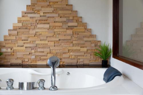 a bathroom with a sink and a brick wall at 2 Secluded Villas Private Resort in Nathon Bay